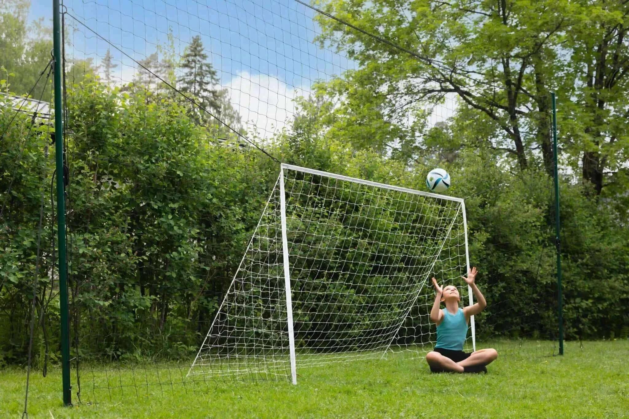 3-in-1 soccer trainer with goal, rebounder, and backstop in backyard setting