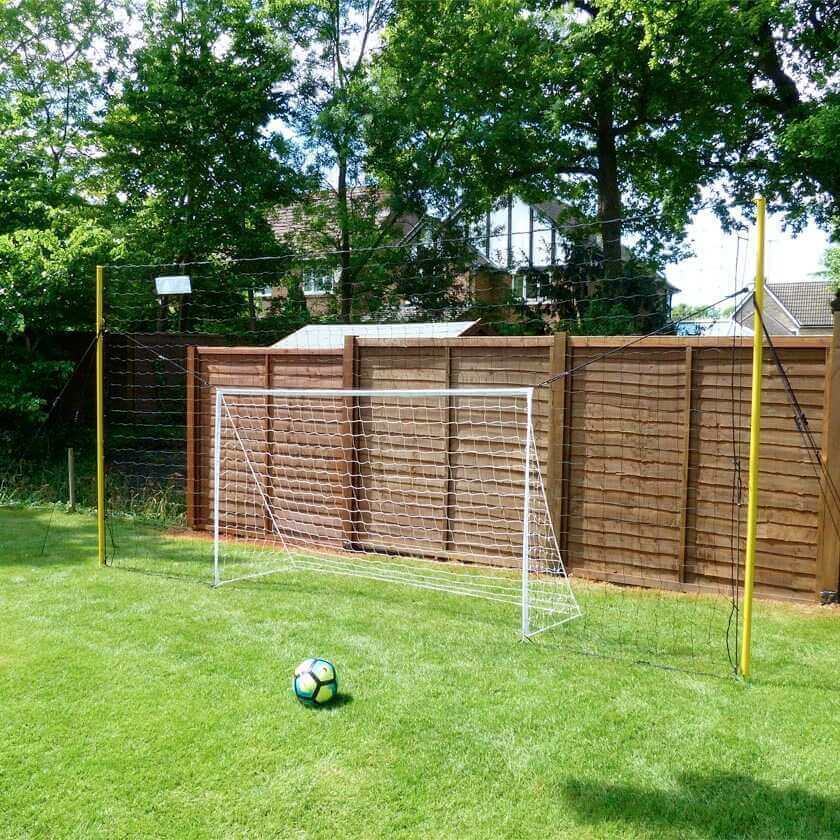 Junior 3-in-1 soccer goal trainer with rebounder and backstop in backyard setting