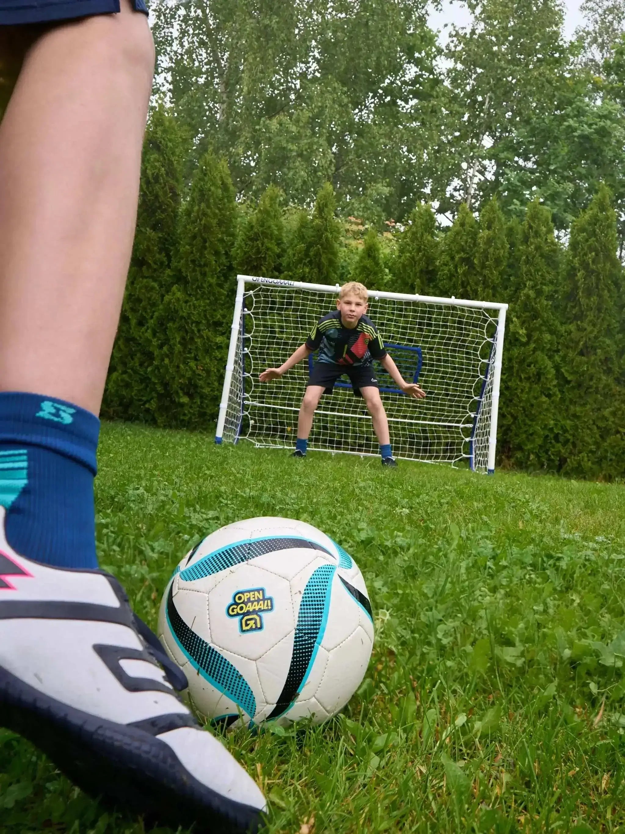 3-in-1 soccer goal rebounder with boy goalie practicing shot in backyard