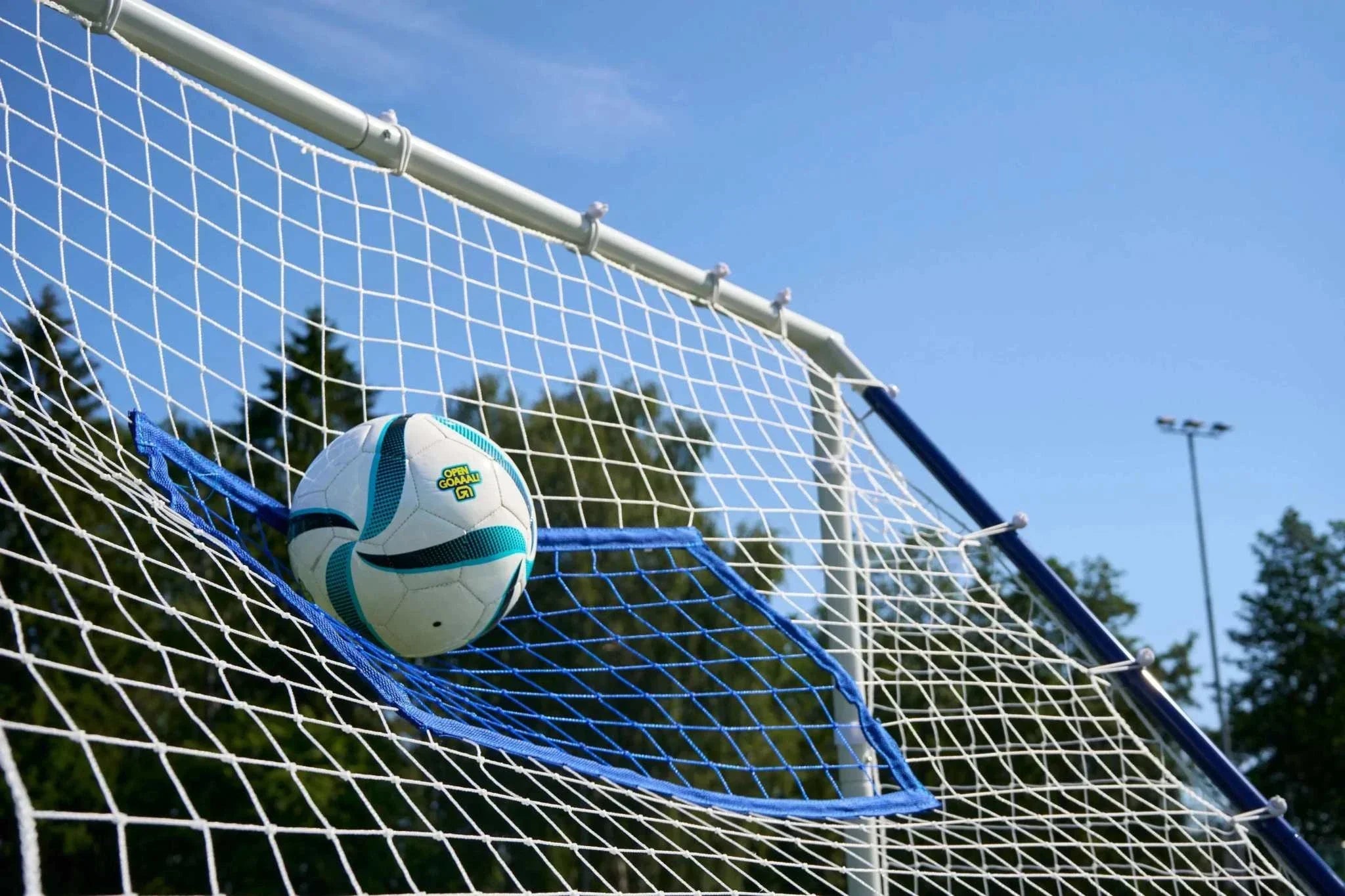 3-in-1 soccer goal rebounder with ball in net outdoors on a sunny day