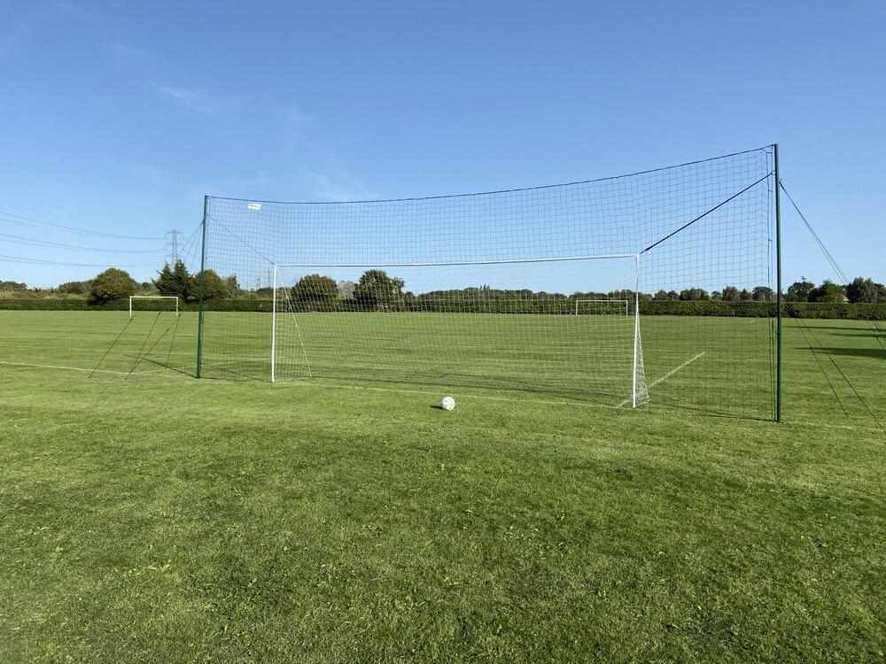 3-in-1 Soccer Goal Trainer with regulation-size goal, rebounder, and backstop in a field.