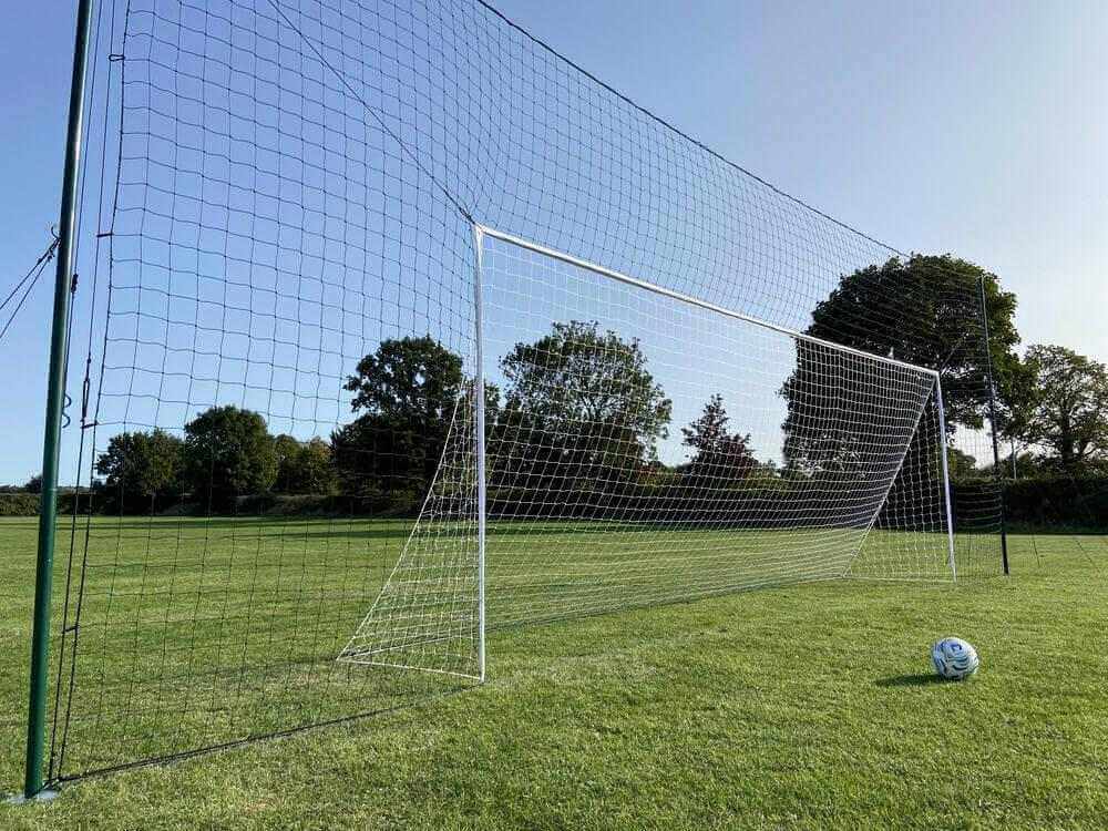 3-in-1 regulation soccer goal trainer with goal, rebounder, and backstop on grass field.