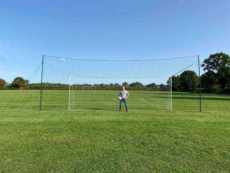 3-in-1 Soccer Goal Trainer featuring a regulation-size goal, rebounder, and backstop on a grassy field.