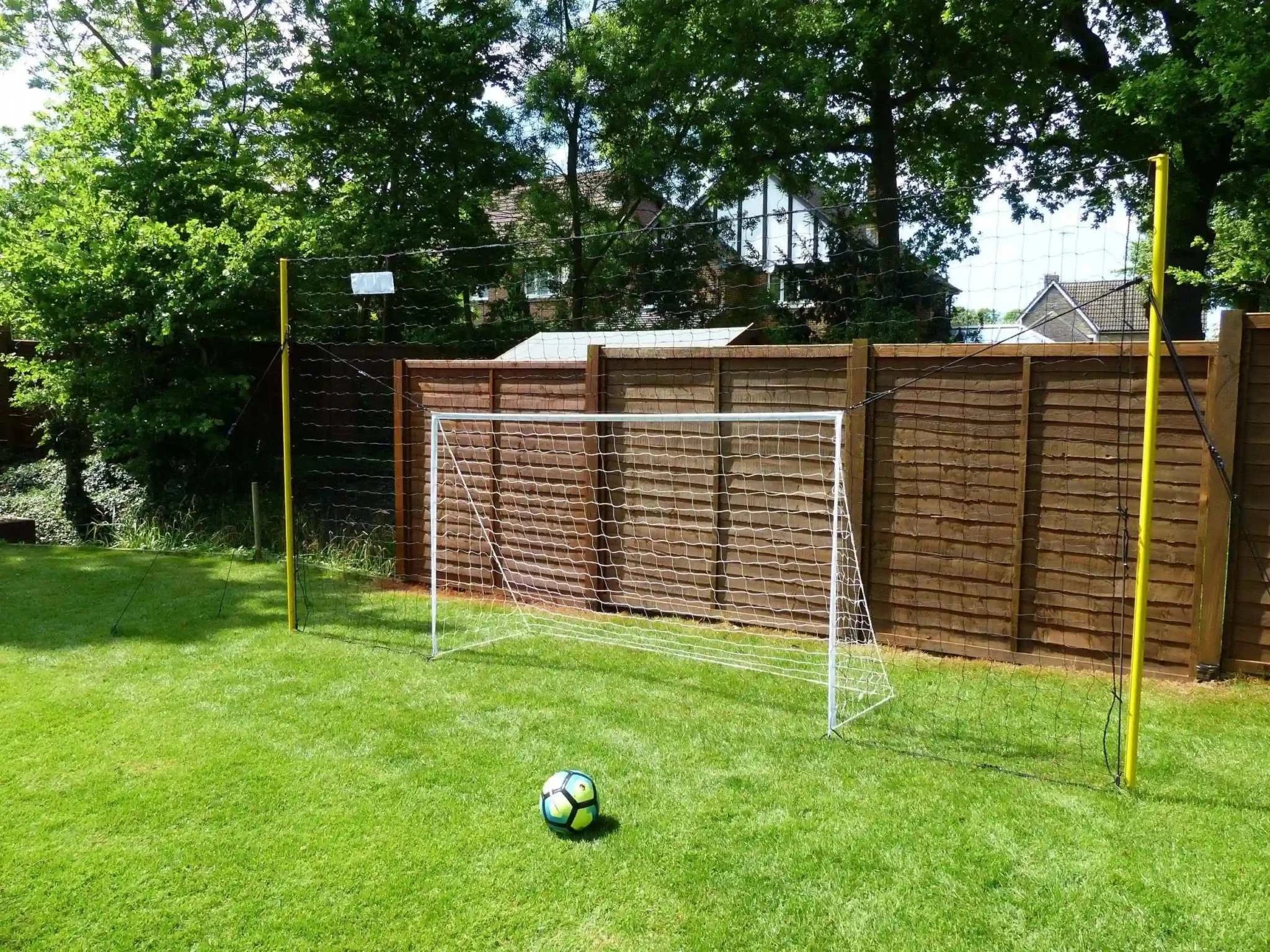 Open Goaaal® Soccer 3-in-1 Trainer with goal, rebounder, and backstop in a backyard setting.
