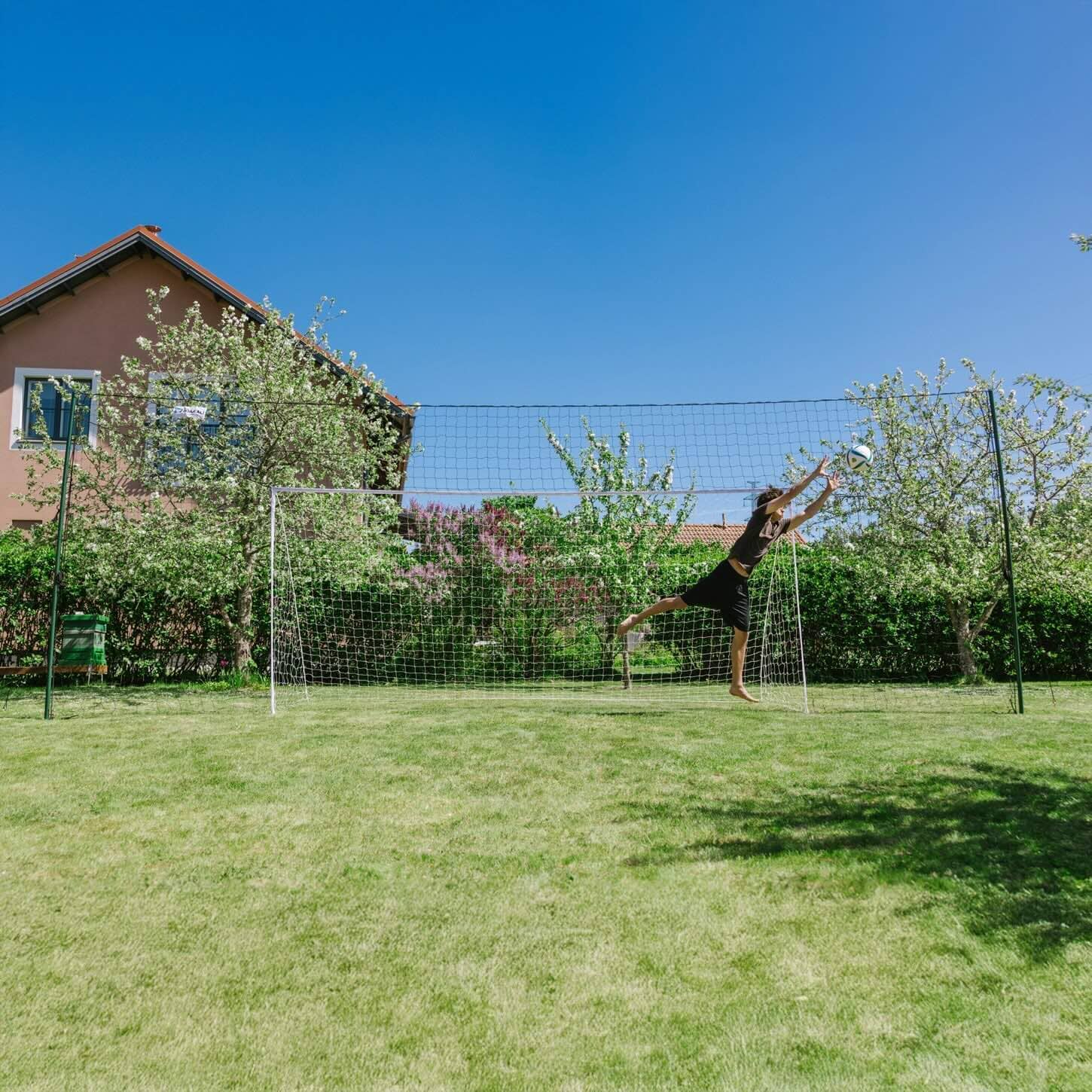 3-in-1 soccer goal trainer set up in backyard for kids' practice