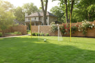 3-in-1 Soccer Goal Trainer set up in backyard with ball on green grass field